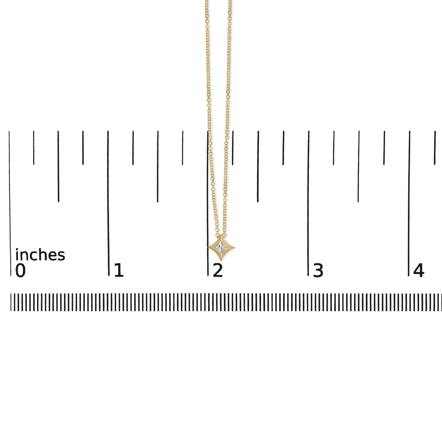 Front-facing shot of a yellow metal necklace with a princess-shaped white gemstone pendant, displayed on a ruler for size reference.