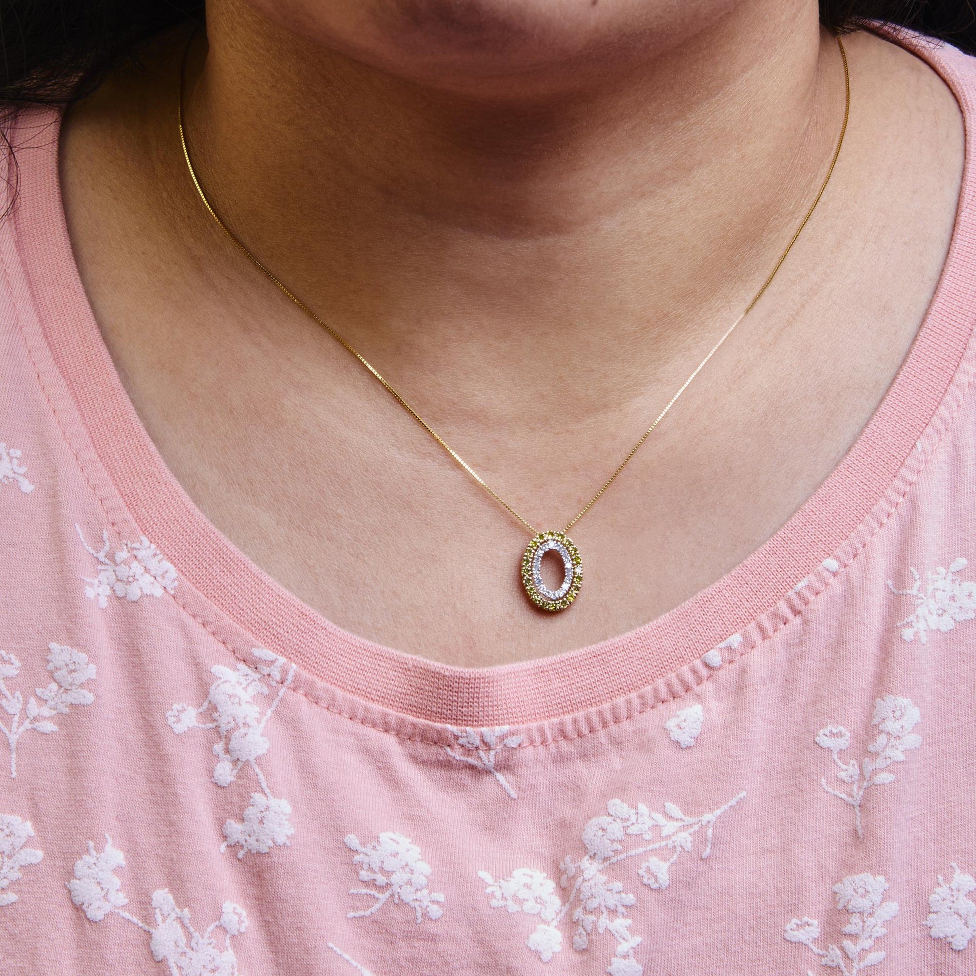 Yellow and white gemstone oval pendant necklace on a model, front close-up angle.