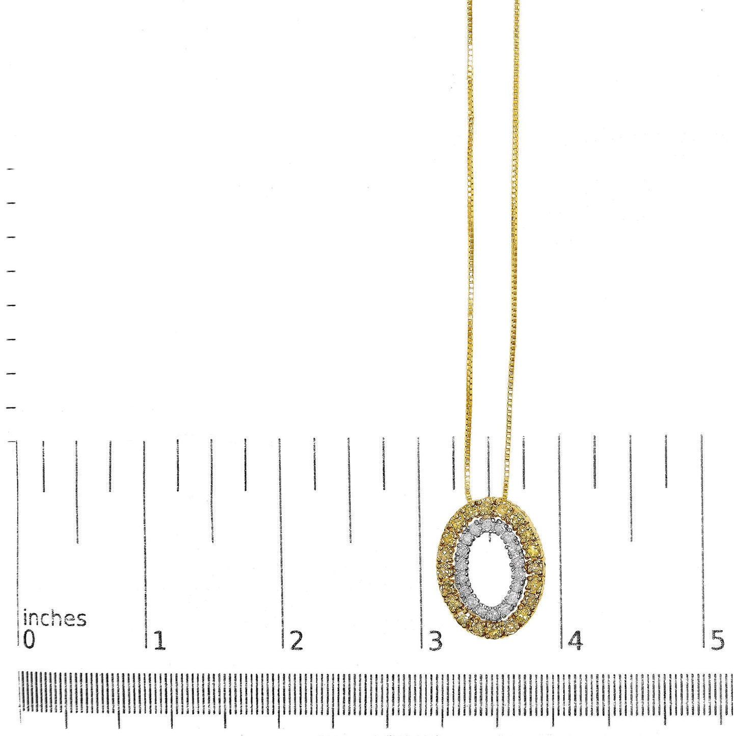 Close-up frontal view of a two-tone yellow and white metal necklace pendant with an oval shape, featuring round yellow and white gemstones in prong settings, displayed on a ruler for size reference.