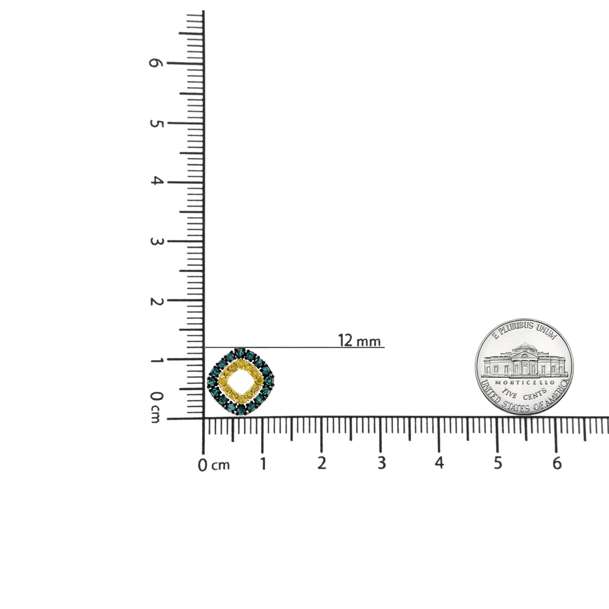 Close-up front view of a white metal necklace pendant with round blue and white gemstones in prong settings, shown on a ruler and next to a coin for size reference.