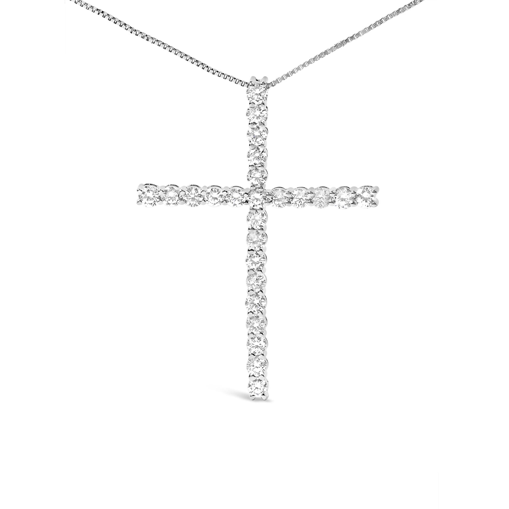 Front-facing view of a white metal cross-shaped necklace pendant with round white gemstones in prong settings on a thin white metal chain.