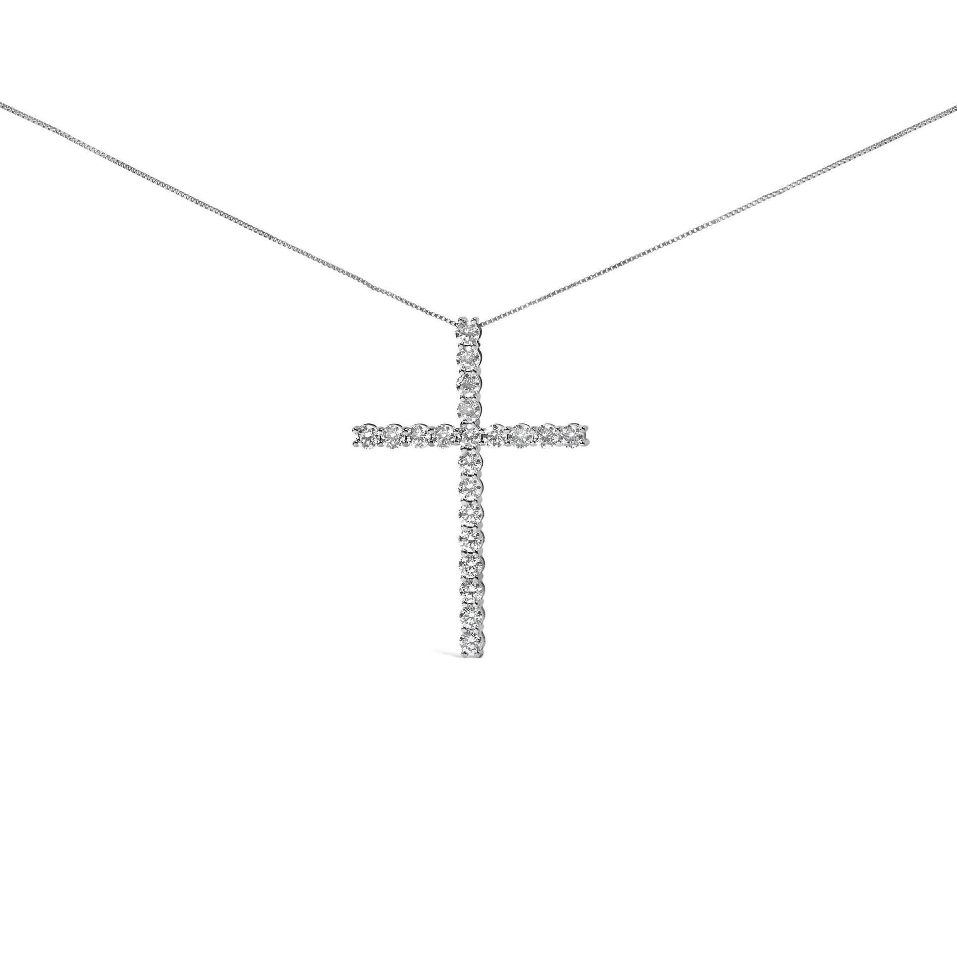 Front-facing shot of a white metal necklace with a cross-shaped pendant featuring round white gemstones in prong settings.