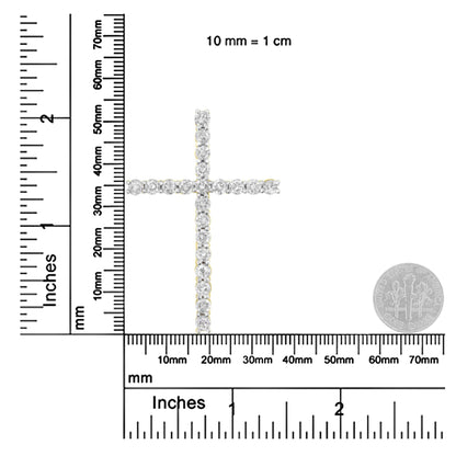 Front-facing image of a yellow metal cross-shaped necklace pendant with round white gemstones in prong settings, shown on rulers for size reference.
