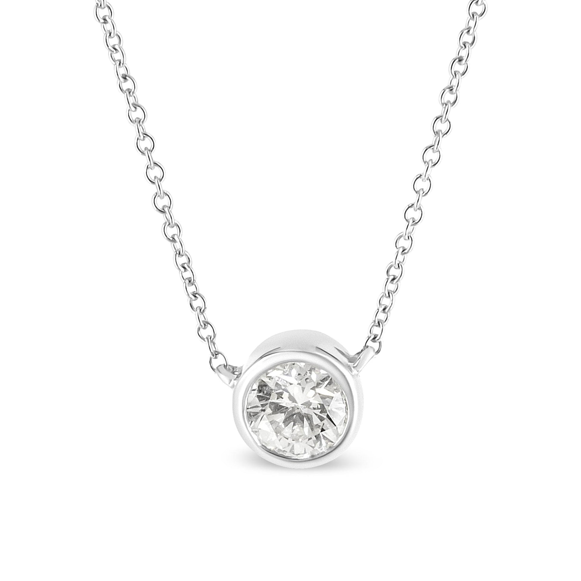 Front angled close-up of a white metal necklace with a single round white gemstone in bezel setting pendant.