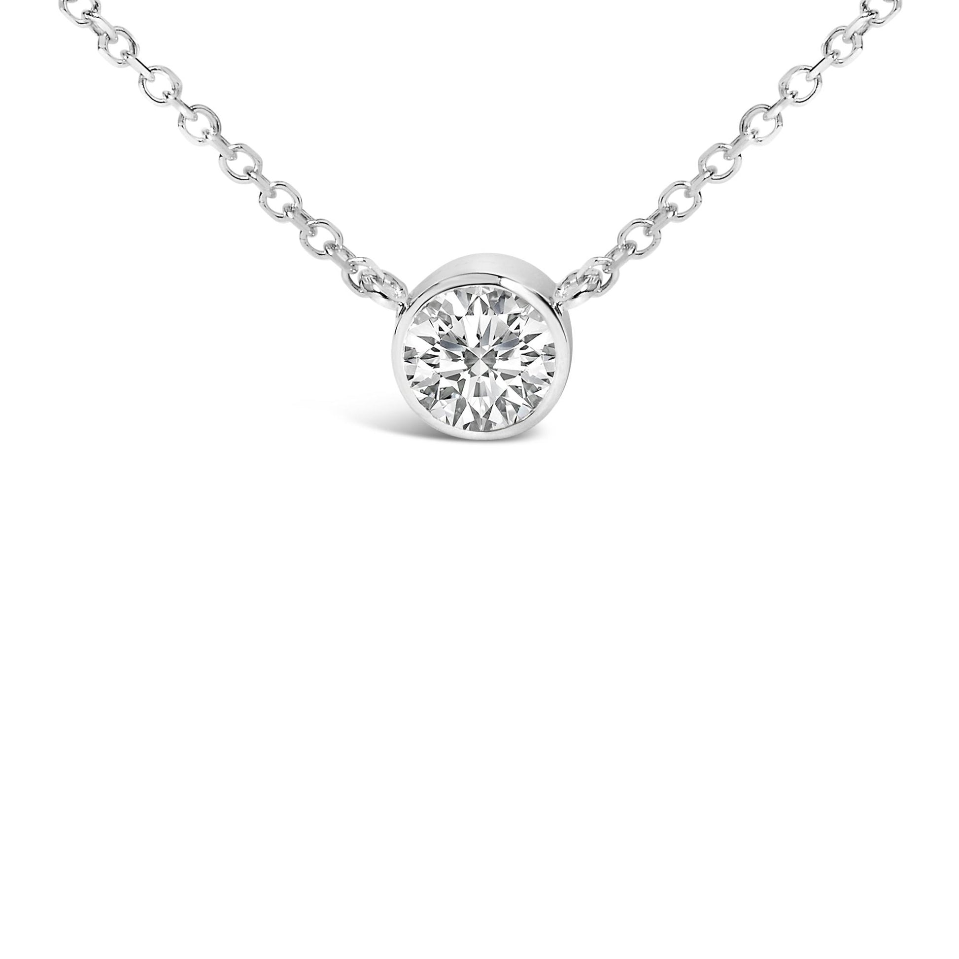 Close-up front angle of a white metal necklace with a round white gemstone in a bezel setting.