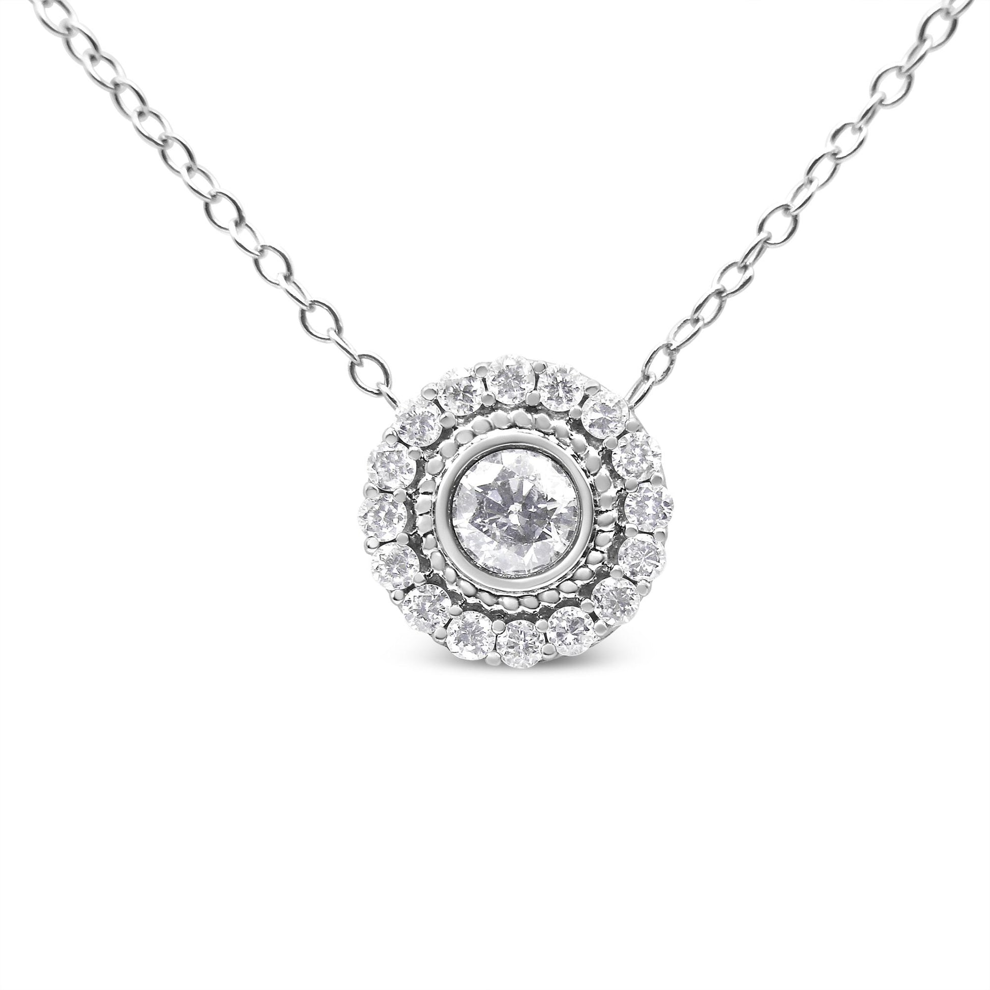 Front view of a white metal necklace with a round pendant featuring a centrally bezel-set round white gemstone surrounded by a halo of pave-set round white gemstones.