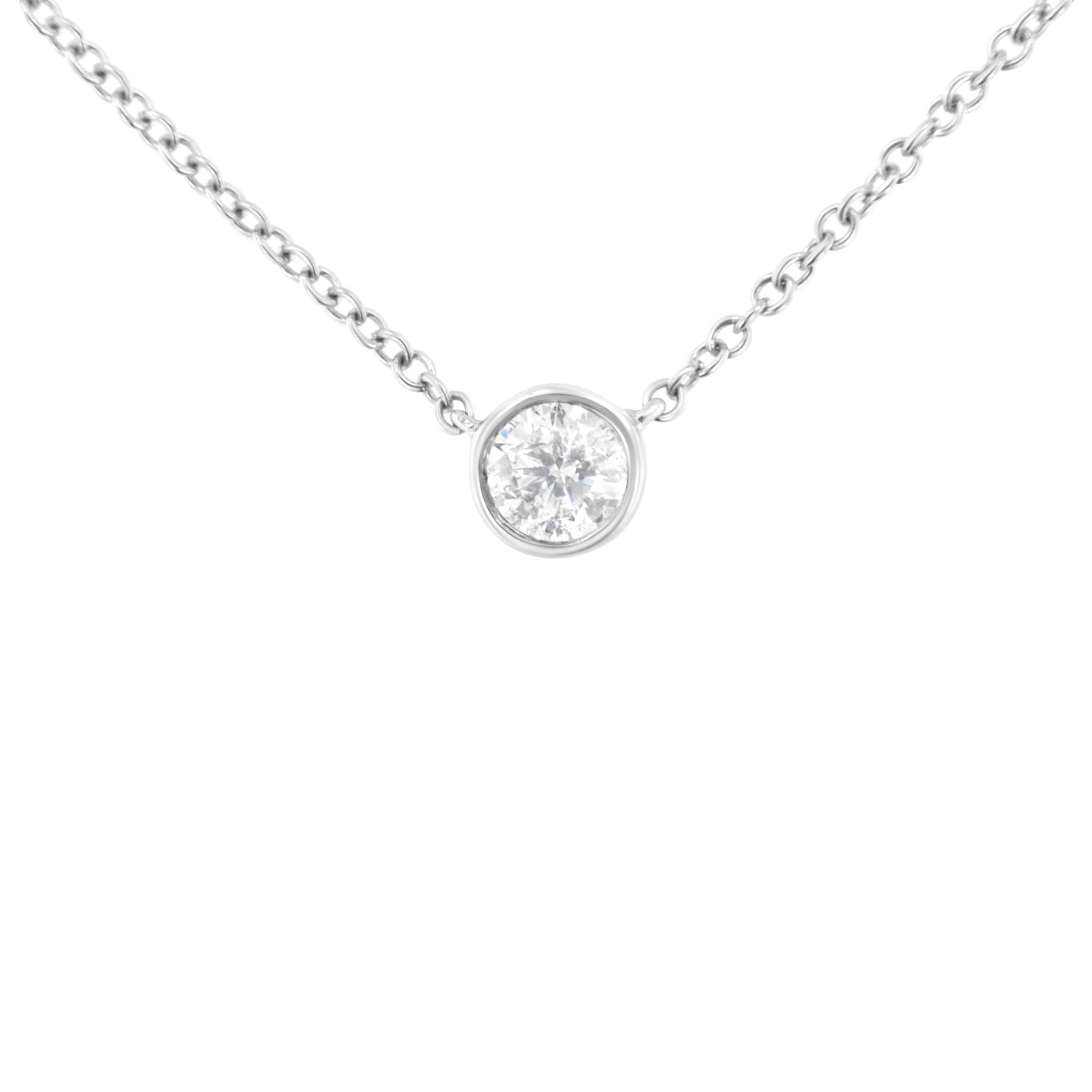 White metal necklace shown from front angle with single round white gemstone in bezel setting pendant.