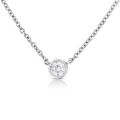 Close-up front view of a white metal necklace with a single round white gemstone in a bezel setting pendant.