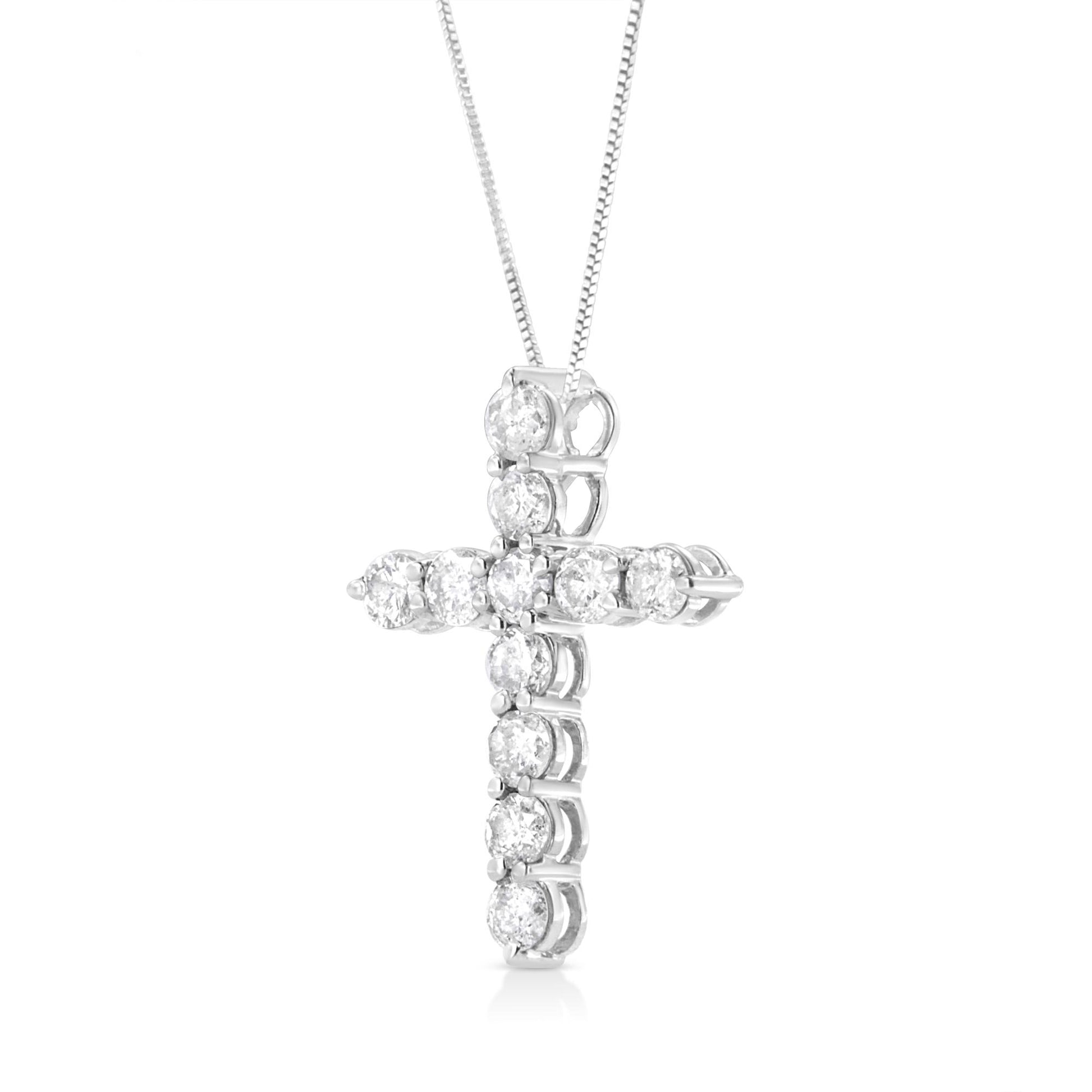Close-up front angled view of a white metal cross-shaped necklace pendant with round white gemstones in prong settings, hanging from a white metal chain.