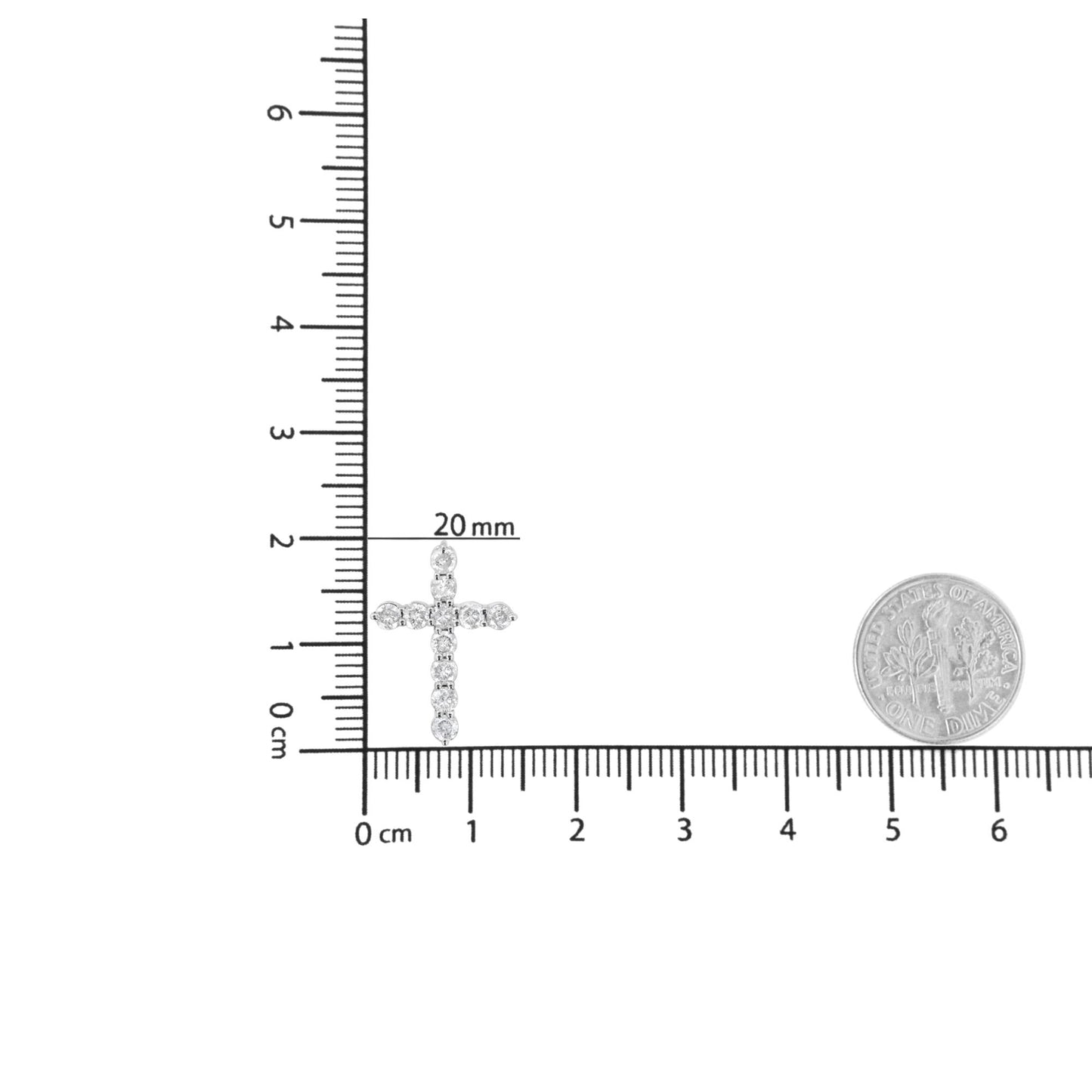 White metal cross-shaped necklace pendant with round white gemstones in prong setting, shown flat on a ruler for size reference with a coin nearby, top-down angle.