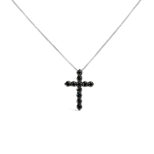 White metal necklace with a cross pendant set with round black gemstones in prong settings, photographed from the front on a white background.