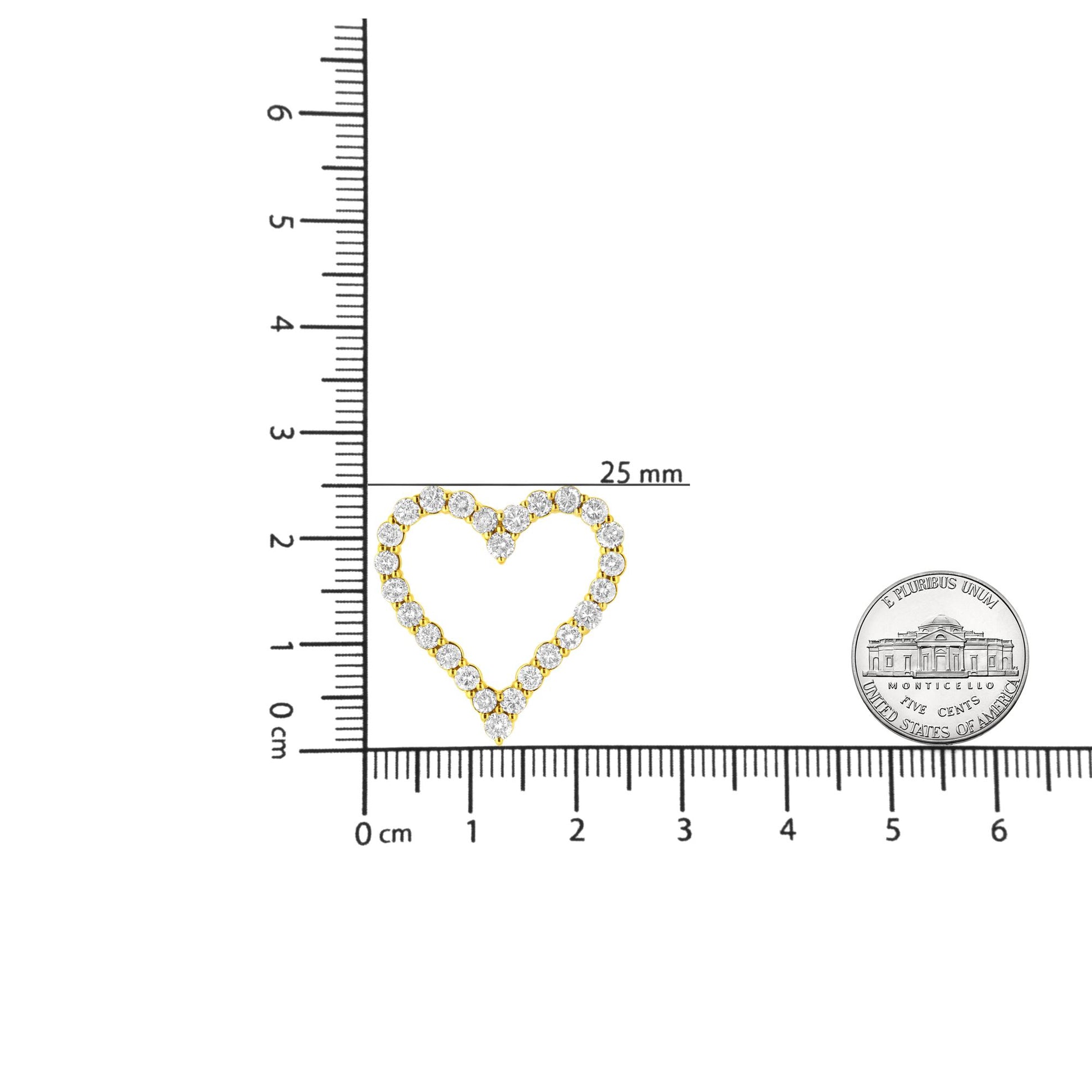 Top-down view of a yellow metal heart-shaped necklace pendant with round prong-set brownish gemstones, shown on a ruler for size reference.