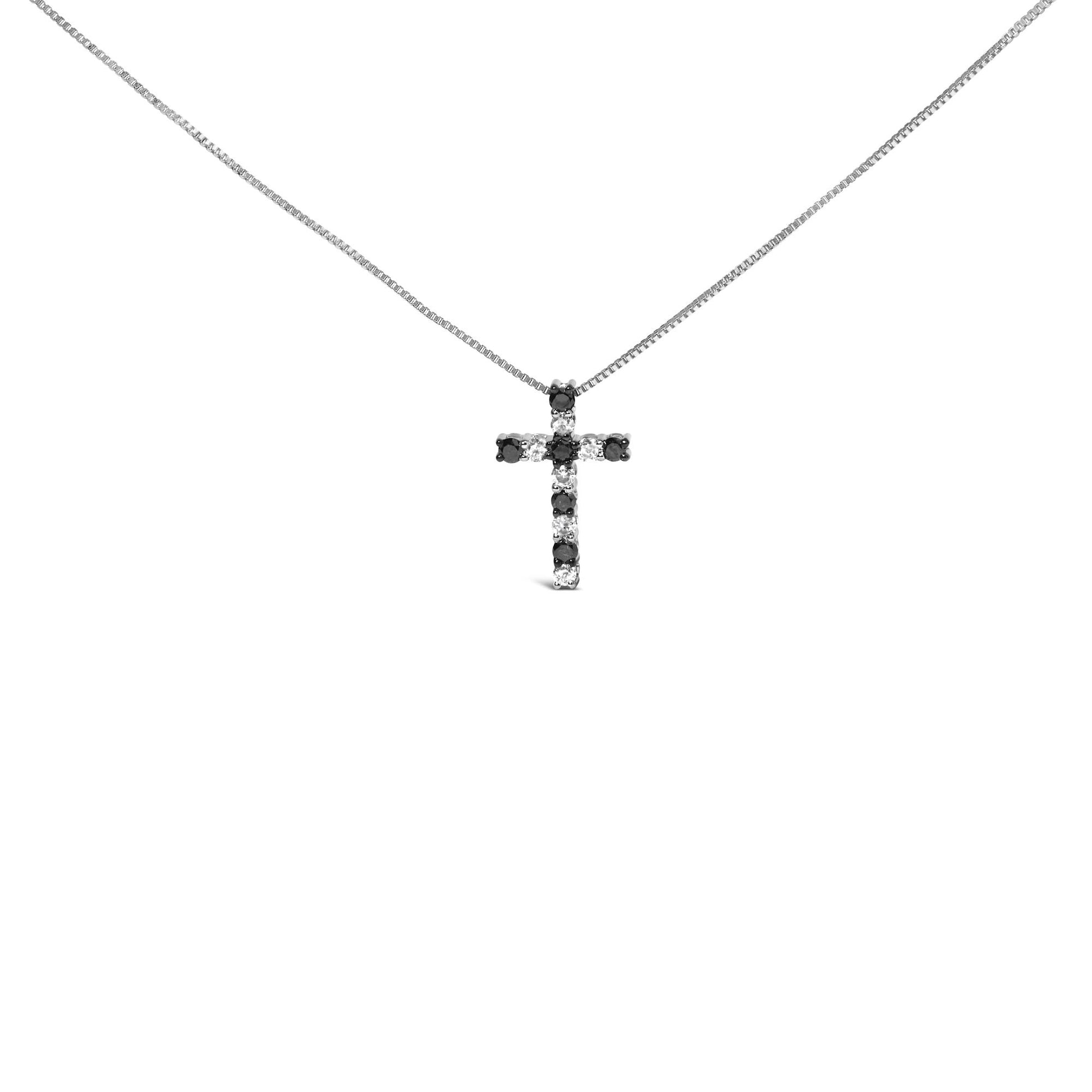 Front view of a white metal necklace with a cross-shaped pendant featuring alternating black and white round gemstones in prong settings.