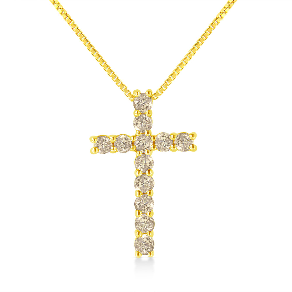 Front-facing shot of a yellow metal cross necklace with round brownish gemstones in prong settings.
