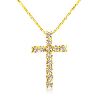 Front-facing shot of a yellow metal cross necklace with round brownish gemstones in prong settings.