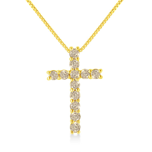 Front-facing shot of a yellow metal cross necklace with round brownish gemstones in prong settings.