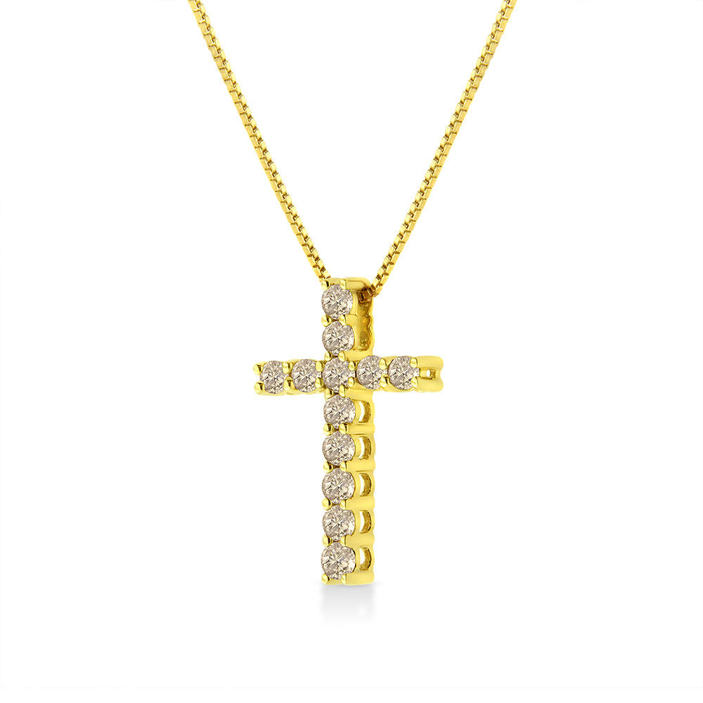Front view of a yellow metal cross pendant necklace with round brownish gemstones in prong settings.
