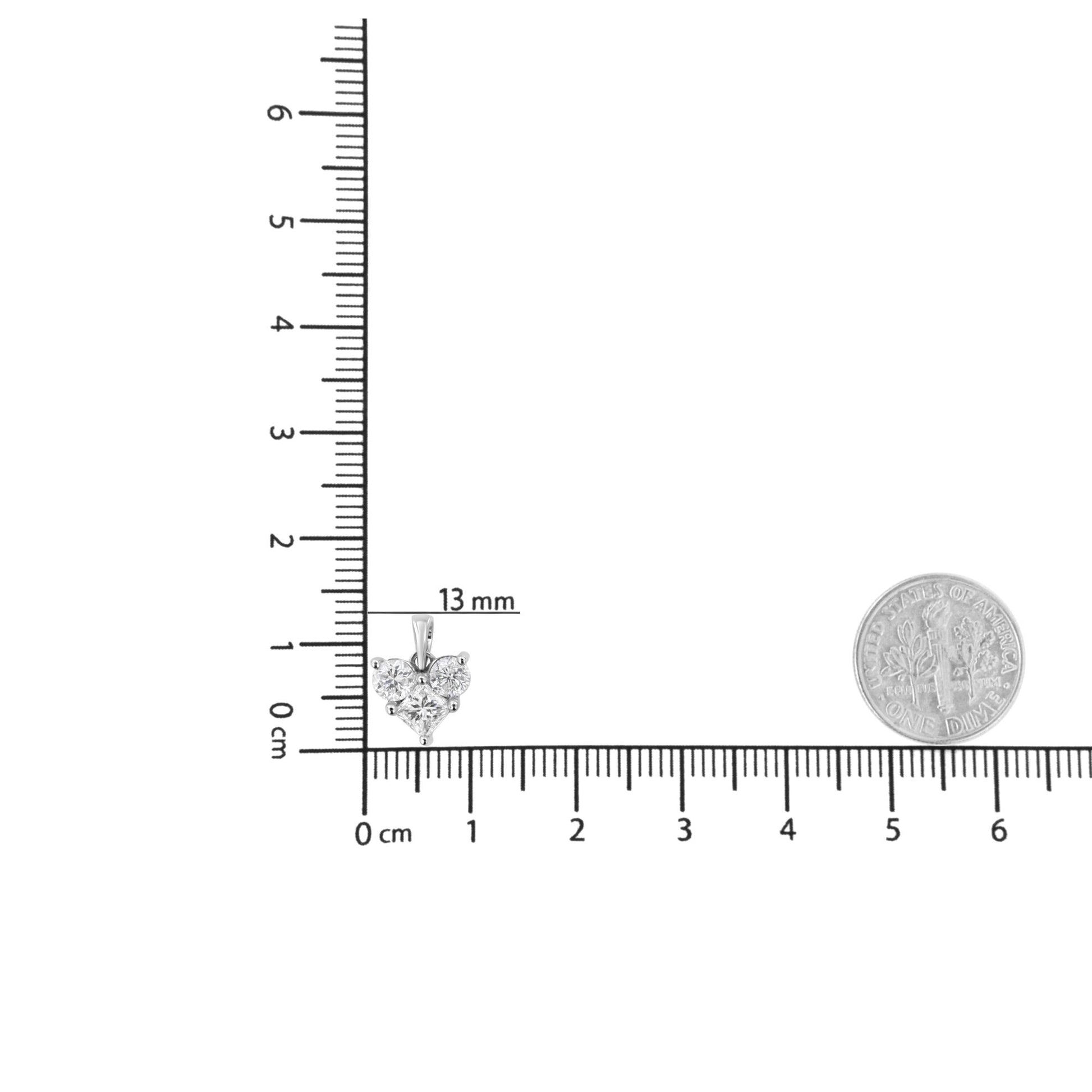 White metal necklace pendant with one princess shape and two round shape white gemstones, shown from the front on a ruler and scale for size reference.