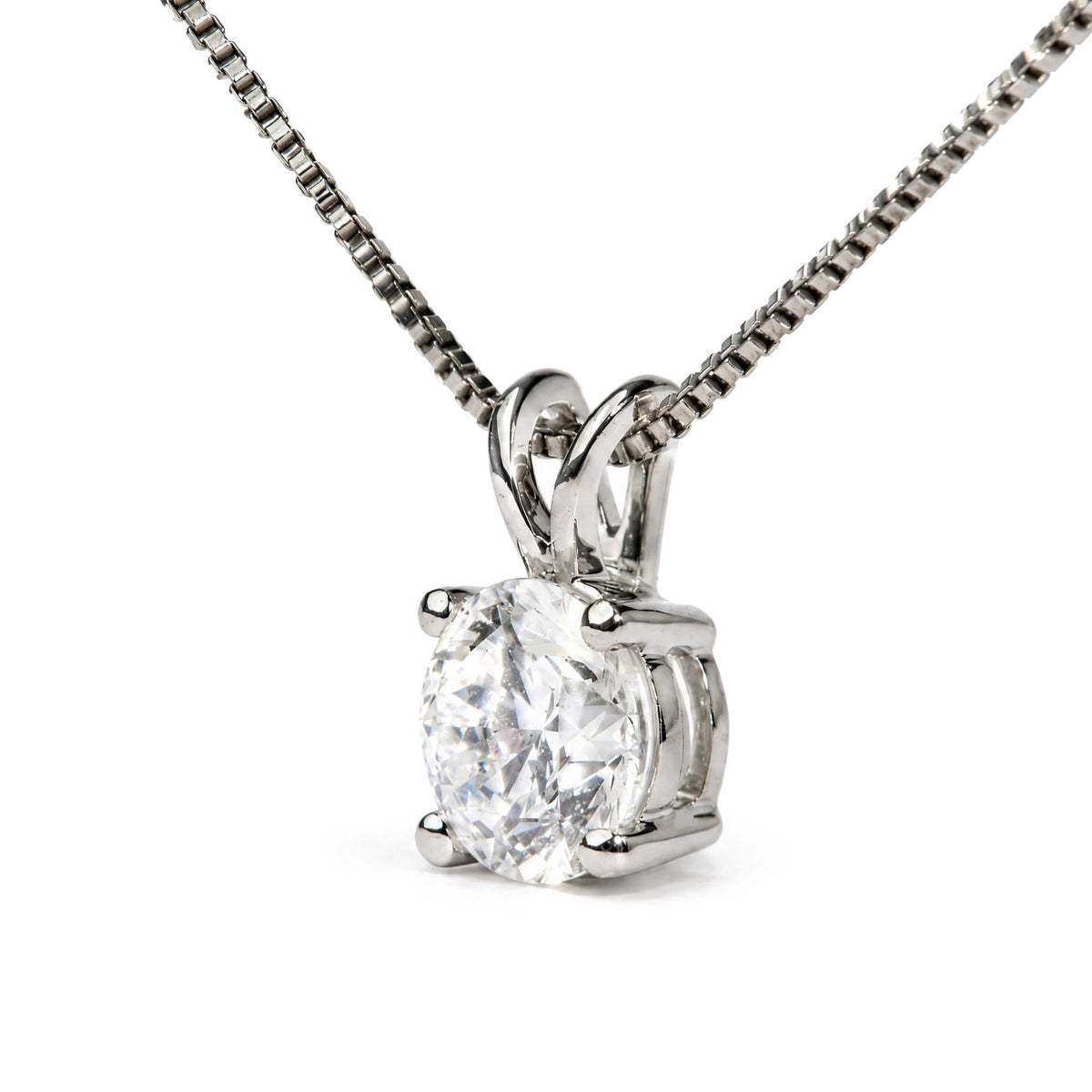 Close-up front angle of a white necklace with a round white gemstone set in a four-prong setting, shown on a white background.