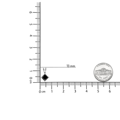 Image of a white metal necklace pendant with a black princess-shaped gemstone in a prong setting, shown on a ruler and scale for size reference from a front angle.