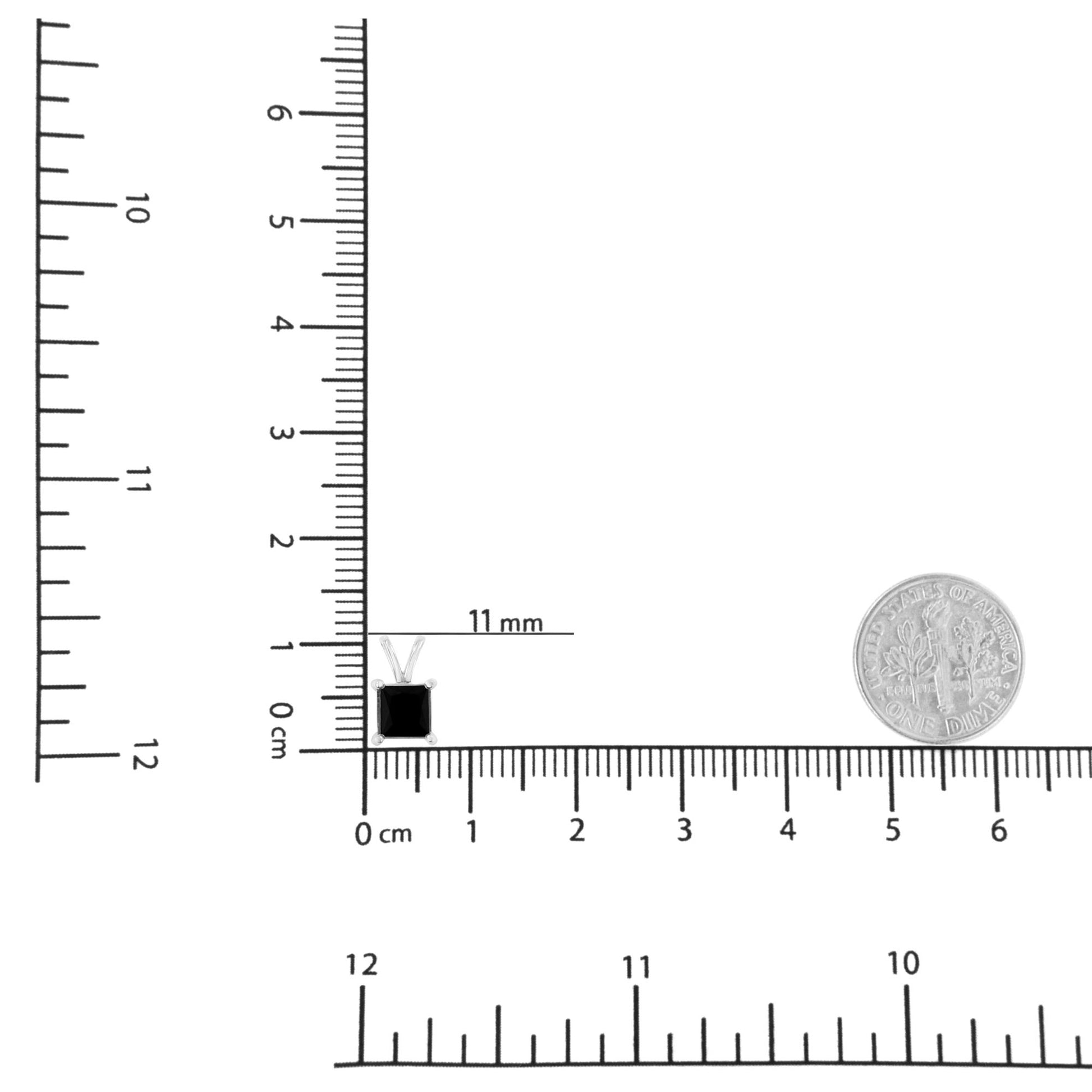 Top-down shot of a white metal necklace with a single black square-shaped gemstone pendant, displayed on a ruler and next to a dime for size reference.