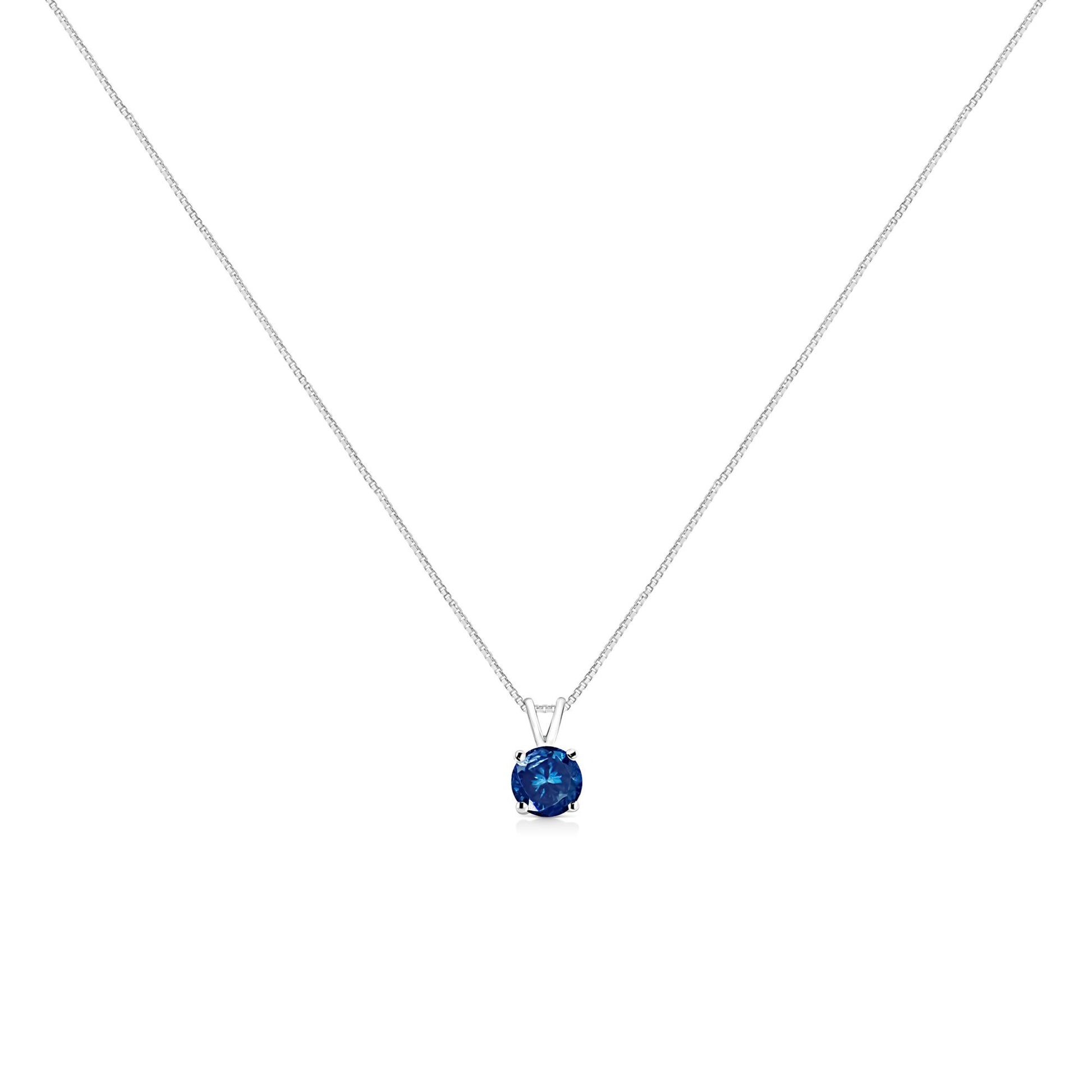 Front-facing view of a white metal necklace with a single round blue gemstone in a prong setting pendant.