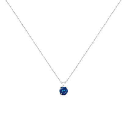 Front-facing view of a white metal necklace with a single round blue gemstone in a prong setting pendant.