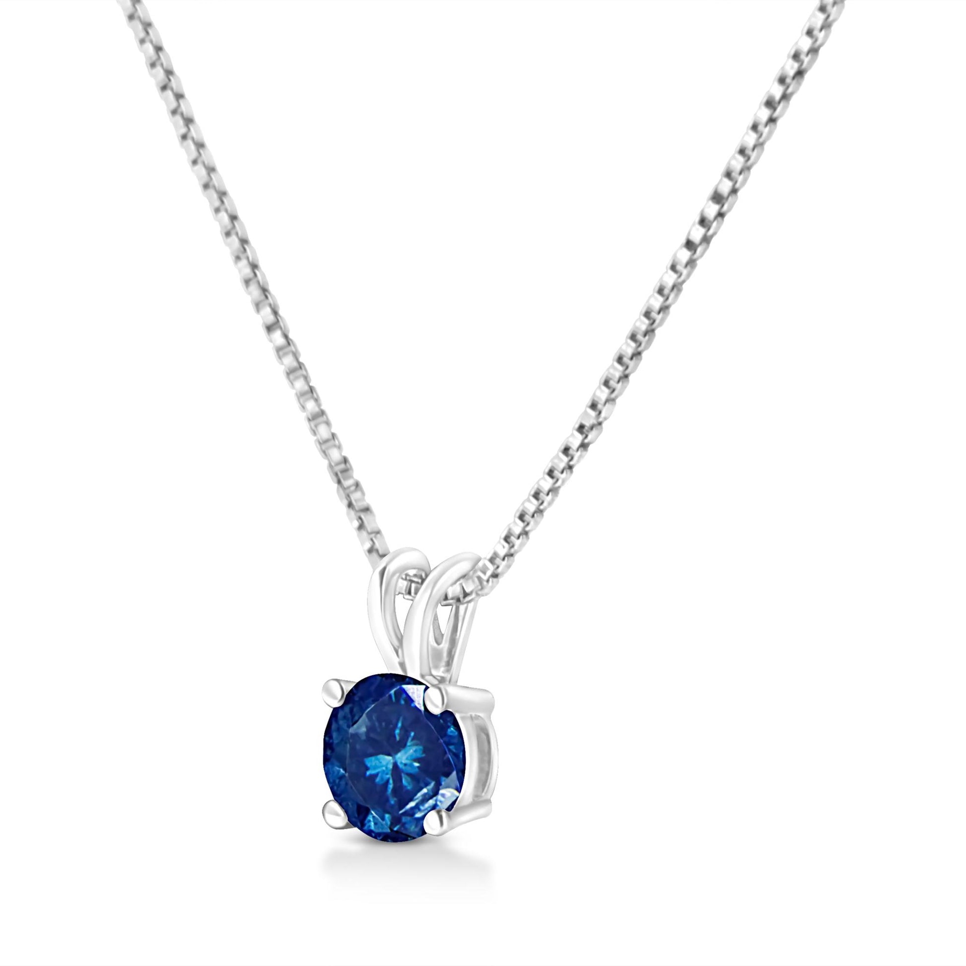 Front angled view of a white metal necklace with a round blue gemstone in a prong setting.