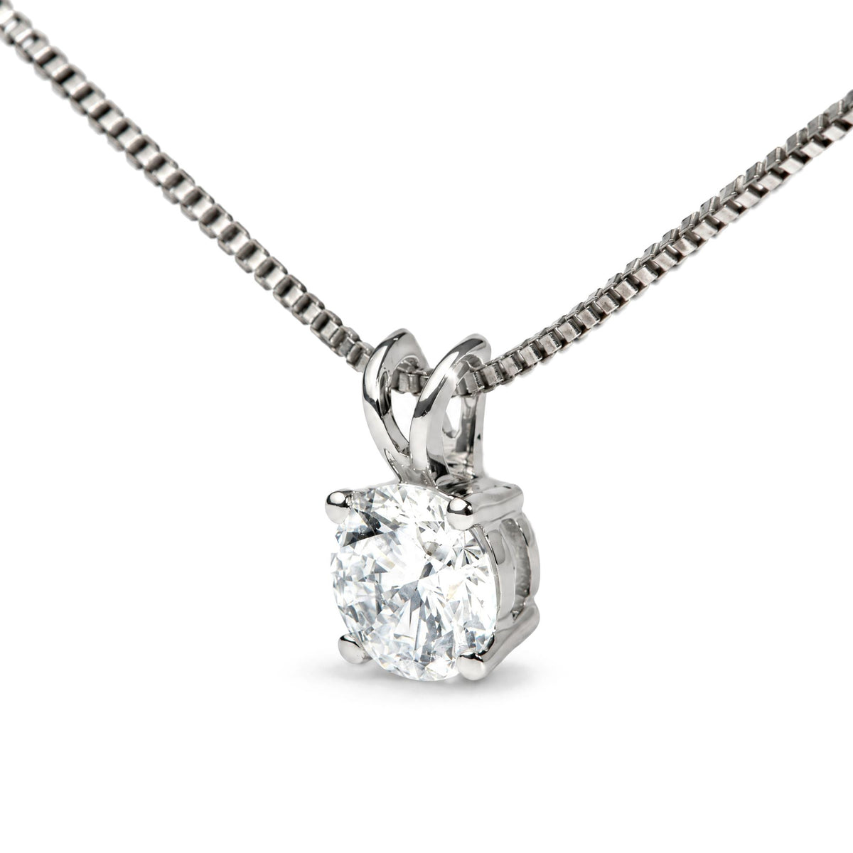 Close-up front angle of a white metal necklace with a round white gemstone set in a four-prong setting.