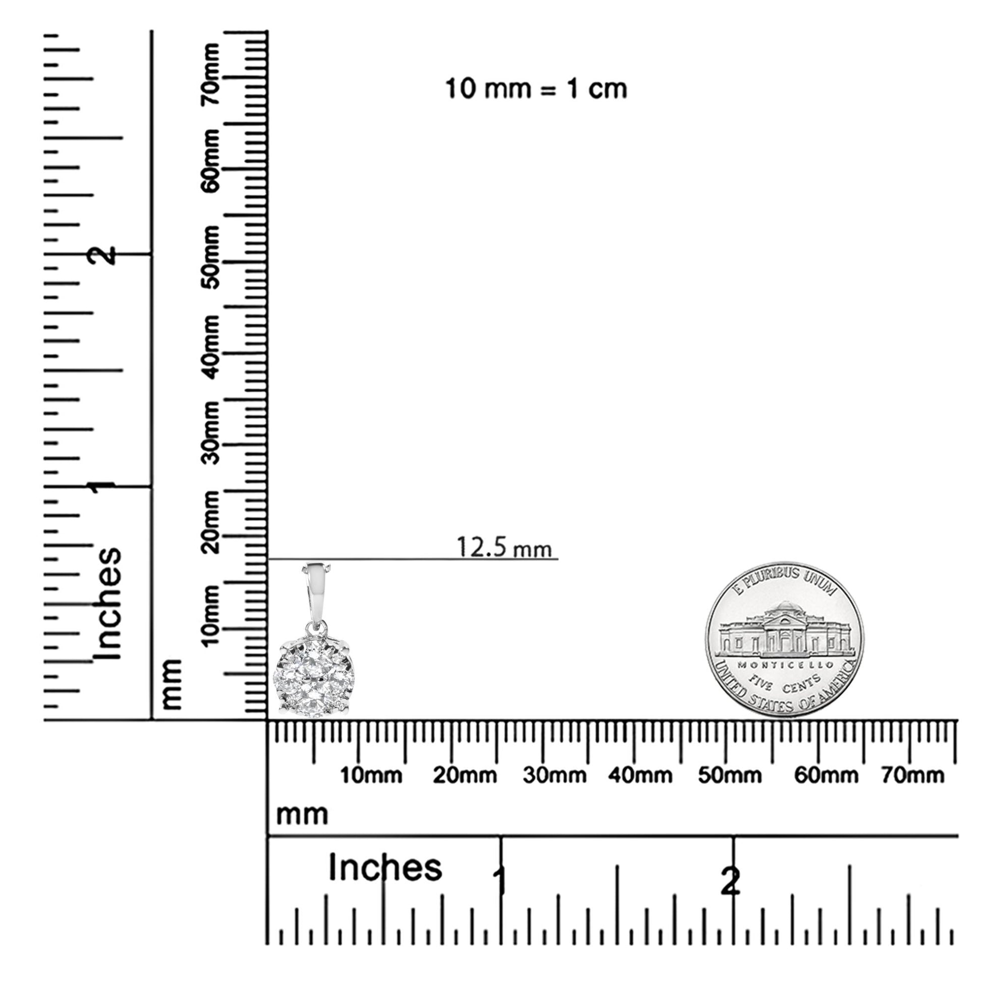Front angle shot of a white metal necklace pendant with multiple round white gemstones in prong settings, displayed on intersecting rulers for size reference.