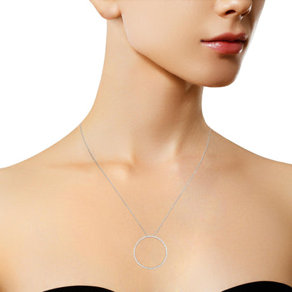 Close-up front view of a model wearing a white metal necklace with a circular pendant set with round white gemstones.