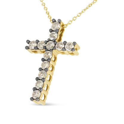 Yellow metal cross-shaped necklace pendant with round champagne-colored gemstones in prong settings, shown angled from the front.