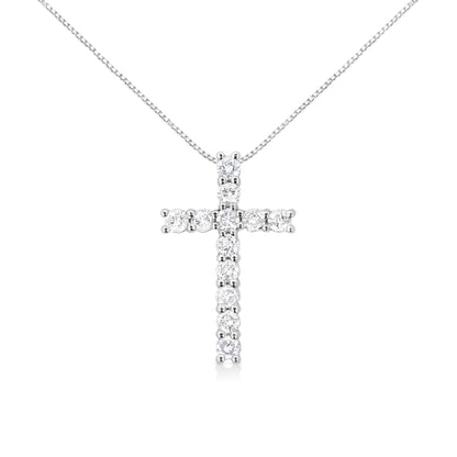 Front angle view of a white metal cross-shaped necklace pendant with round white gemstones in prong settings on a white chain.