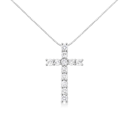 Front angle view of a white metal cross-shaped necklace pendant with round white gemstones in prong settings on a white chain.