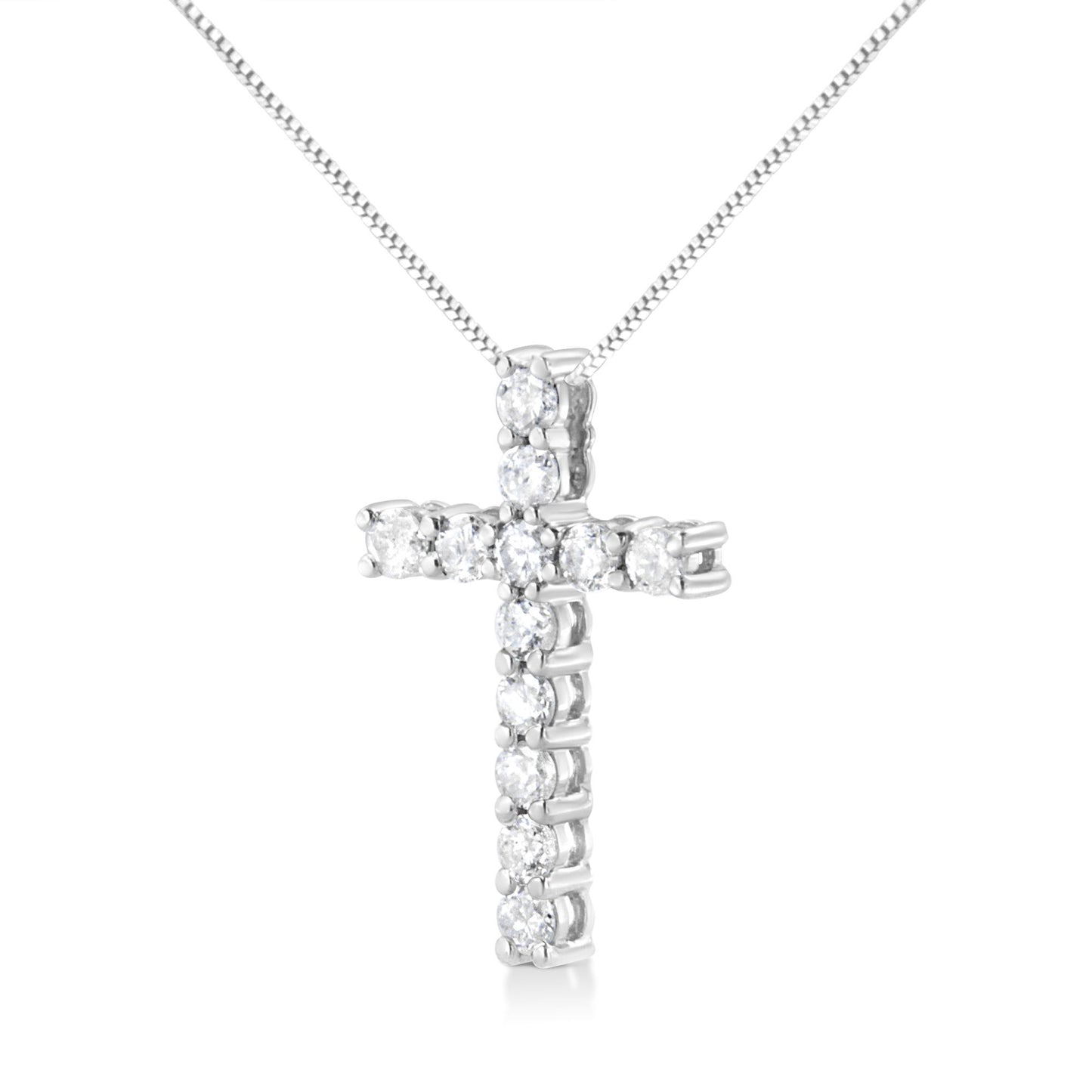 Front-facing shot of a white metal cross-shaped necklace pendant with round white gemstones in prong settings on a white metal chain.