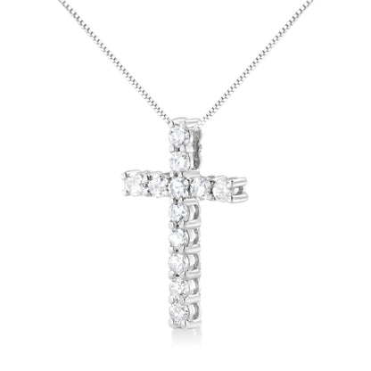 Front-facing shot of a white metal cross-shaped necklace pendant with round white gemstones in prong settings on a white metal chain.
