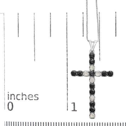 Close-up front view of a white metal cross pendant necklace with alternating black and white round prong-set gemstones, displayed on a ruler for size reference.