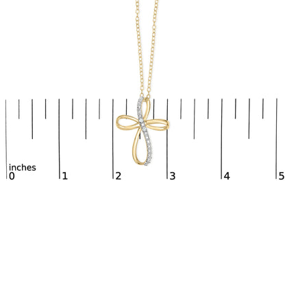 Yellow metal cross-shaped necklace pendant with a row of white gemstones along one arm, shown from the front hanging on a chain against a ruler for size reference.