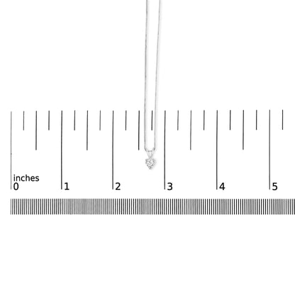 White metal necklace with a heart-shaped white gemstone pendant in a 3-prong setting, displayed hanging above a ruler for size reference, shot from the front.