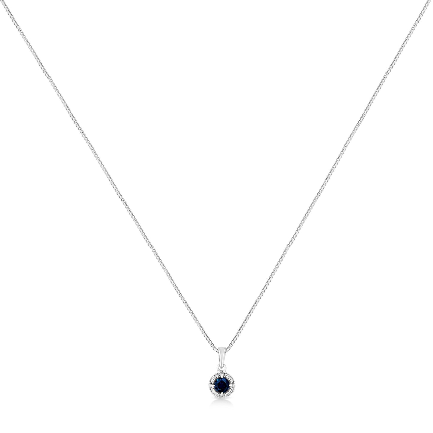 Front-facing shot of a white metal necklace with a round blue gemstone pendant in a four-prong setting.