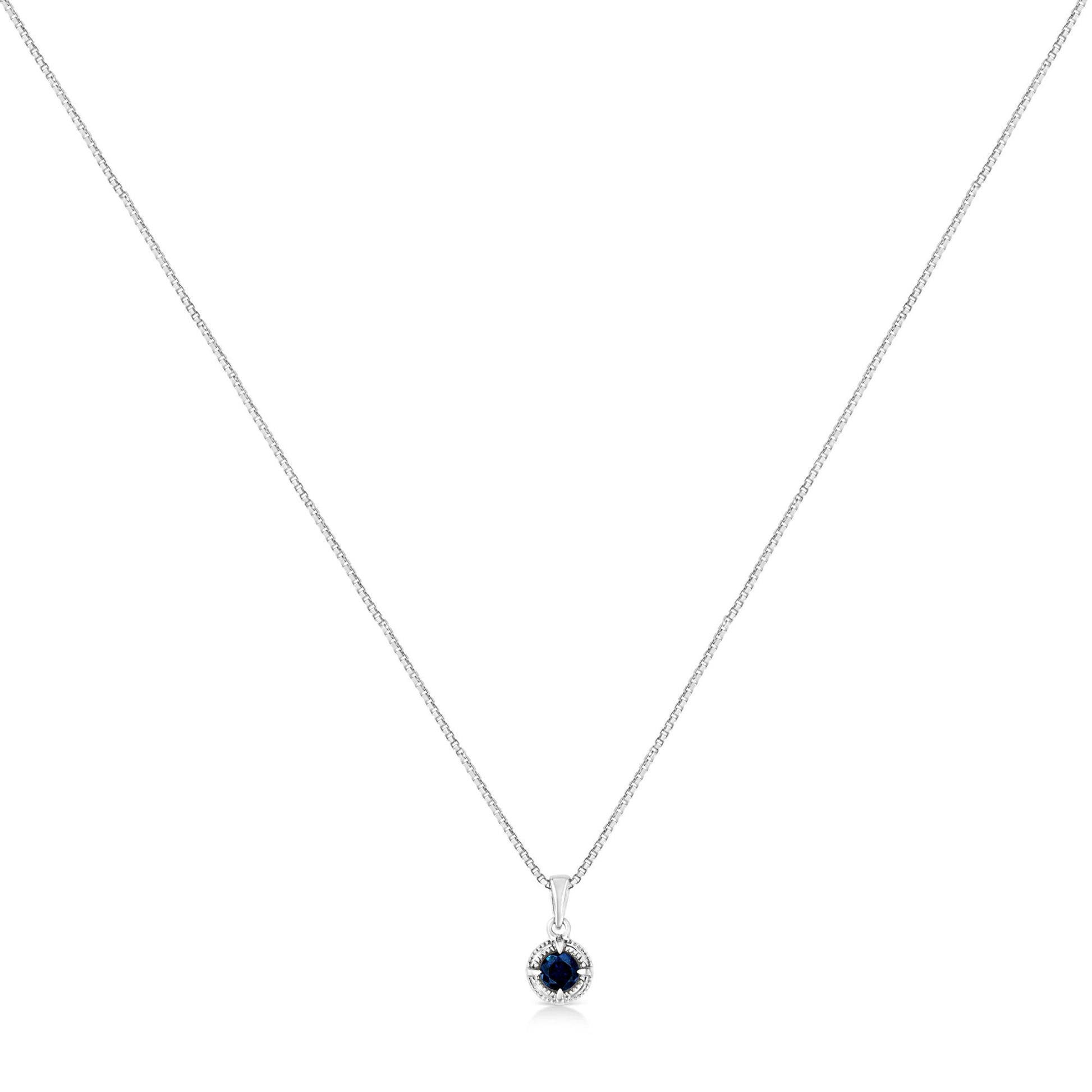 Front-facing shot of a white metal necklace with a round blue gemstone pendant in a four-prong setting.
