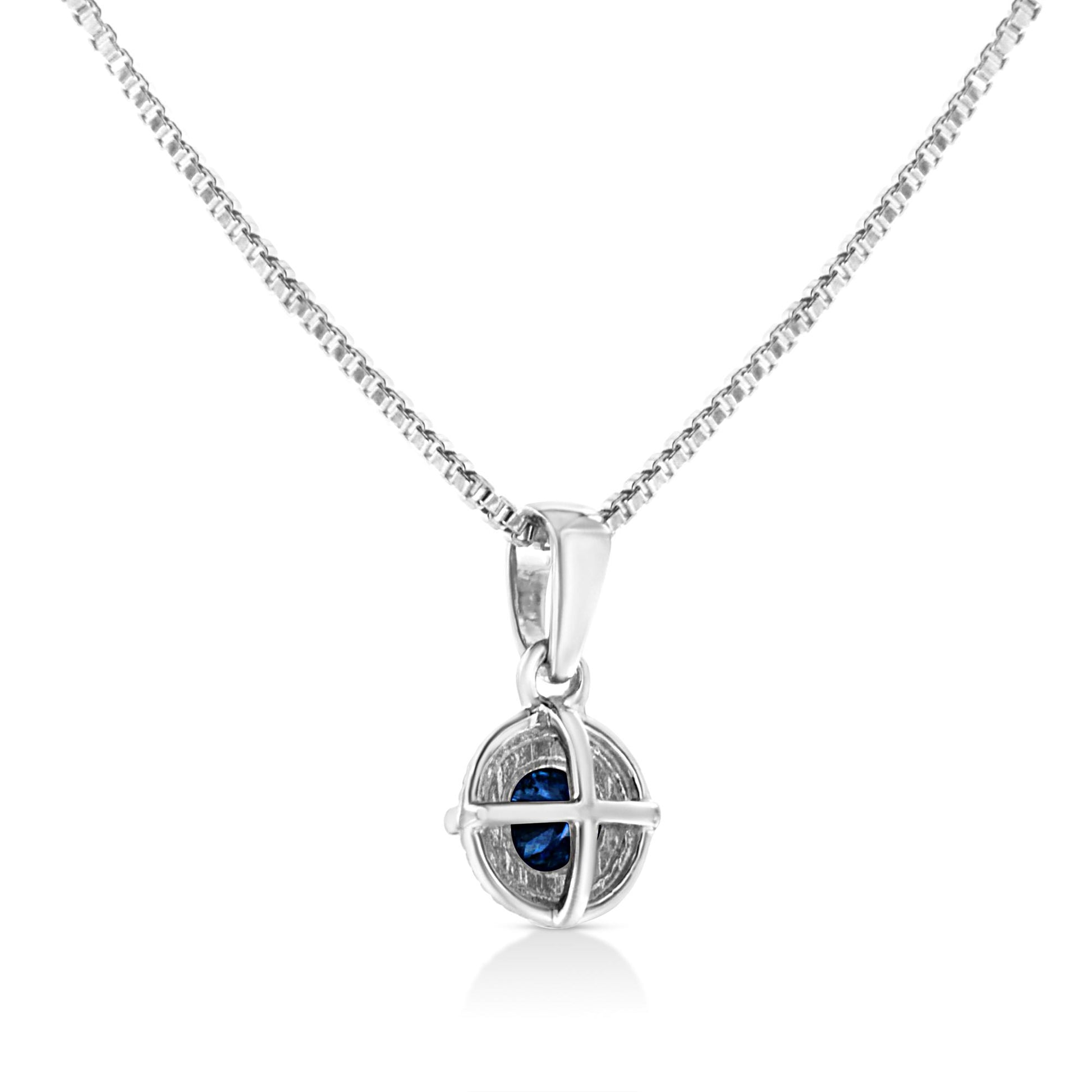 Front-facing shot of a white metal necklace with a round pendant featuring a blue gemstone held by a four-prong setting.