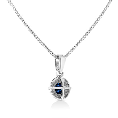 Front-facing shot of a white metal necklace with a round pendant featuring a blue gemstone held by a four-prong setting.