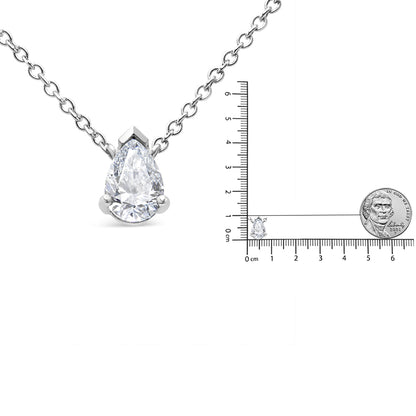 Front view of a white metal necklace with a pear-shaped white gemstone in prong setting, shown next to a ruler and a coin for size reference.