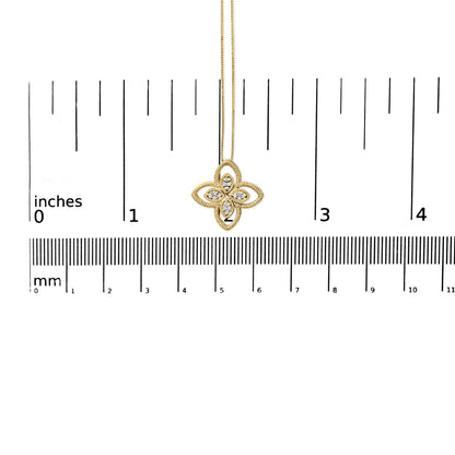 Yellow metal necklace with a flower-shaped pendant featuring white round gemstones in prong settings, shown from the front on a ruler for size reference.