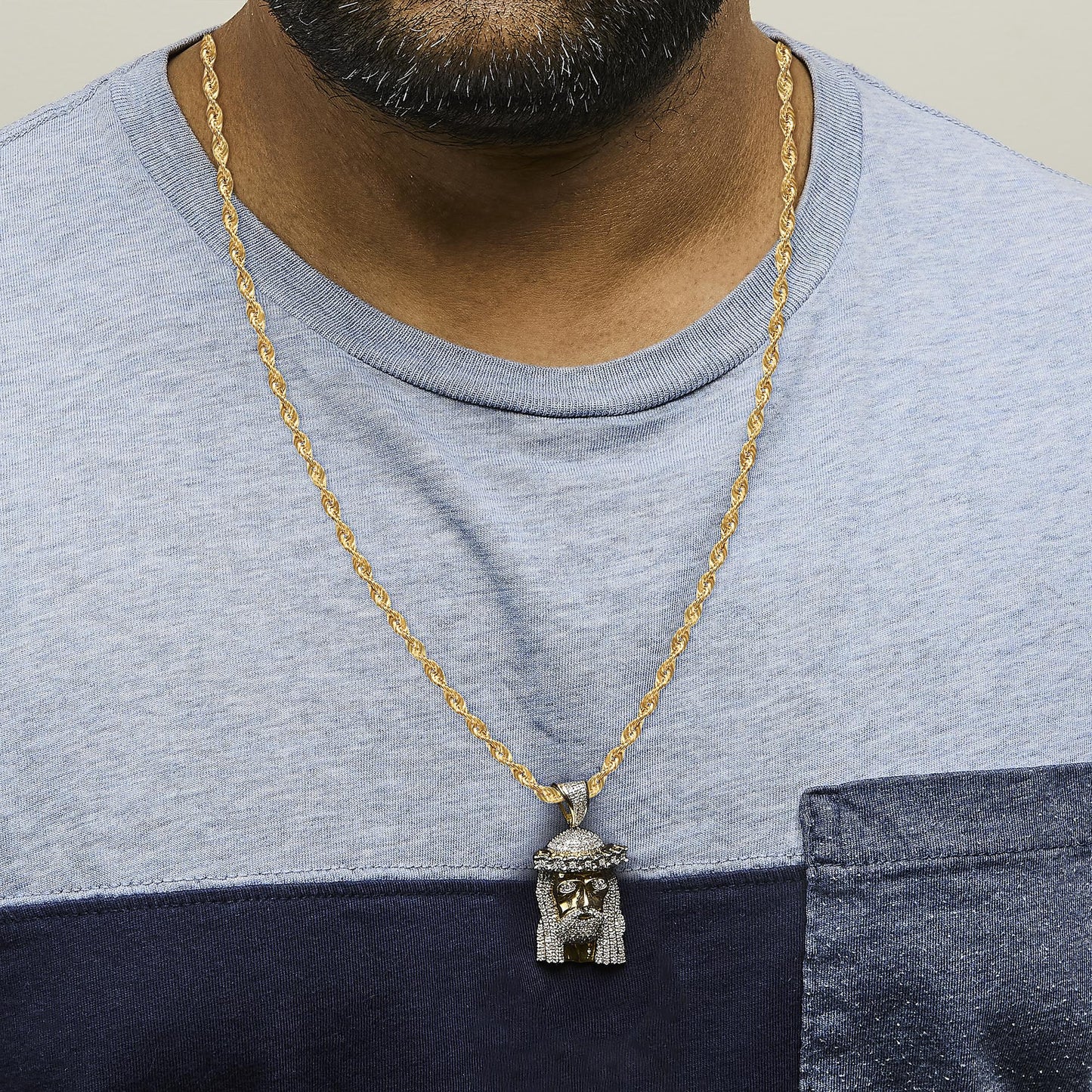 Yellow metal necklace with a pendant featuring white gemstones in pave setting, shown worn on a model from a front view angle.
