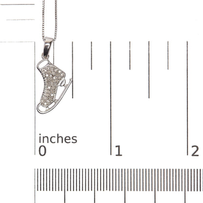 Sterling silver diamond ice skate pendant necklace shown with a scale reference
