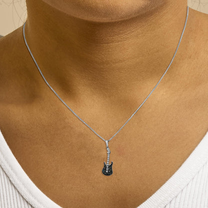Close-up front view of a white metal necklace on a model featuring a guitar-shaped pendant with blue round gemstones in prong settings.