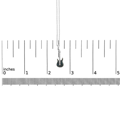 White metal necklace with a guitar-shaped pendant featuring blue round gemstones in prong settings, shown from the front on a ruler for size reference.