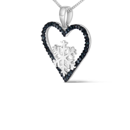 Close-up front angle of a white metal heart-shaped necklace pendant with blue round prong-set gemstones outlining the heart and a snowflake design inside, displayed on a white background.